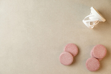 Creative arrangement of pink tablets and funnel on a smooth surface