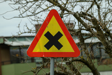 A bright triangular warning sign is displayed prominently, signaling drivers to be cautious of a...