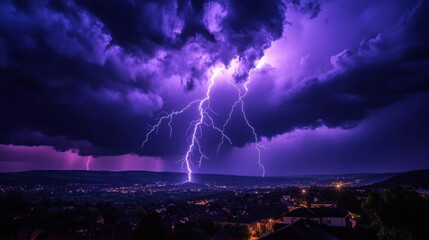 Fototapeta premium Dramatic purple lightning strikes illuminate the night sky over a serene landscape during a thunderstorm.