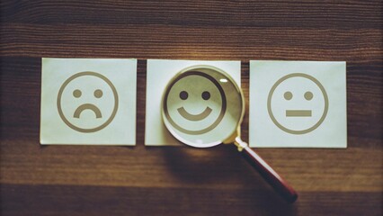 Customer feedback concept with smiley face evaluation and magnifying glass on wooden background