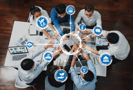 This image captures a diverse team engaged in a collaborative business meeting focused on sustainability strategies, with charts and technology fostering innovative ideas. Amity