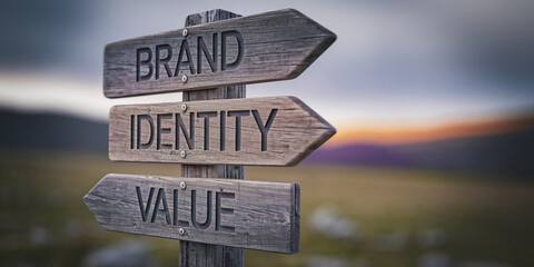 Wooden signpost with three directional arrows indicating "brand", "identity", and "value", set against a blurred mountain landscape at sunset, showcasing the core elements of successful branding