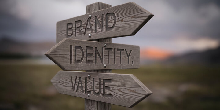 Wooden signpost with three directional arrows indicating "Brand," "Identity," and "Value," set against a blurred landscape background, symbolizing brand building choices and direction