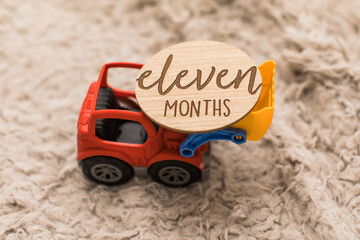 a little red construction truck vehicle car carrying eleven months old sign 