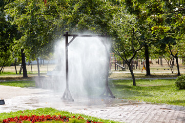 Water spray frame for cooling in hot weather on city street in Kyiv, Ukraine. Water mist cooling...