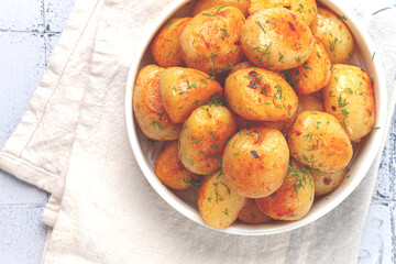 Baked new potatoes, with butter and dill, on a white plate, at home, no people,