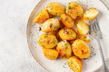 half-eaten fried new potatoes, with butter and dill, on a white plate, with a fork, at home, no...