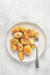 half-eaten fried new potatoes, with butter and dill, on a white plate, with a fork, at home, no people,