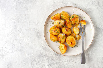 half-eaten fried new potatoes, with butter and dill, on a white plate, with a fork, at home, no people,