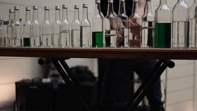 Glass bottle instrument street performance hands strike liquid-filled bottles with sticks creating rhythmic tunes raw sound art blending music science and urban creativity