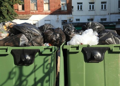 Plastic trash containers. A big, green trash cans for general household waste. Garbage equipment for household waste. Garbage cans for food waste and trash. Environmental situation and garbage in town
