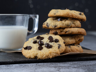 stack of chocolate cookies accompanied by a glass of milk