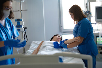 Nurse checking patient blood pressure in hospital room