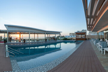 Beautiful sunset over elegant poolside area at a luxury hotel overlooking the city skyline