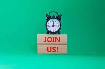 Join us symbol. Concept word Join us on wooden blocks. Beautiful green background with alarm clock....