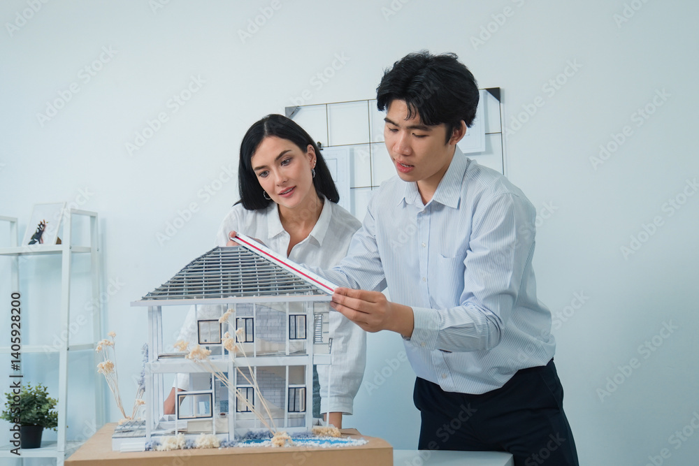 Poster portrait of cooperative engineer team working together to measure house model by using ruler and arc