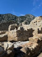 Exploring ancient ruins surrounded by mountains under a clear blue sky