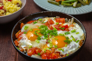 Shakshuka Jewish dish of eggs with tomatoes and green onions