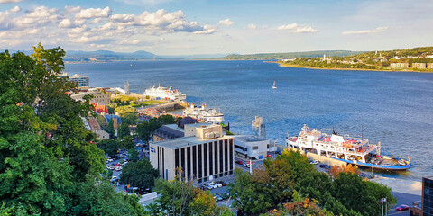 Naklejka premium Magnificent Wide angle panorama view on a brillant summer day from the top of the Dufferin terrace of the St. Lawrence river with the town of Levi on the eastern shore in Quebec city, Canada