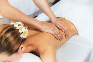 Caucasian woman customer enjoying relaxing anti-stress spa massage and pampering with beauty skin recreation leisure in day light ambient salon spa at luxury resort or hotel. Quiescent