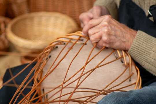 artisan making wicker basket closeup hands in a traditional event party in Galicia. Selective focus