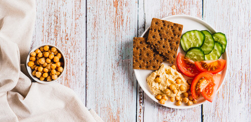 Vegetarian plate with chickpeas and vegetables on the table top view web banner