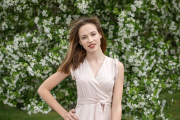 Fototapeta premium Young beautiful girl posing in a blooming garden