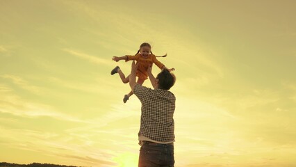 happy family life concept. father plays with little child picnic park. girl daughter soars air....