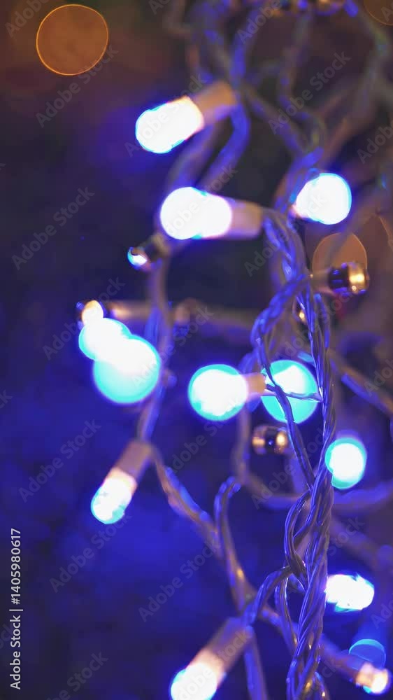 Poster close-up, bokeh-style video of colorful string lights with a focus on the intertwined wires, creatin