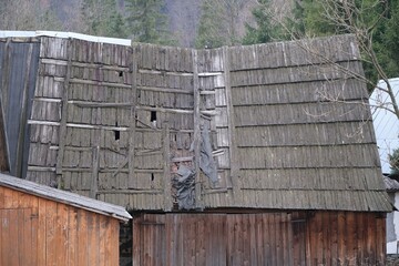 Close-up of an old sloping roof with damaged wooden tiles