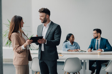 Business people discussing using digital tablet in office meeting room
