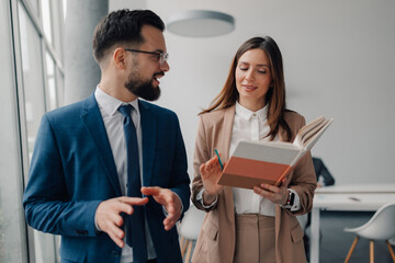 Businesspeople discussing notes in modern office