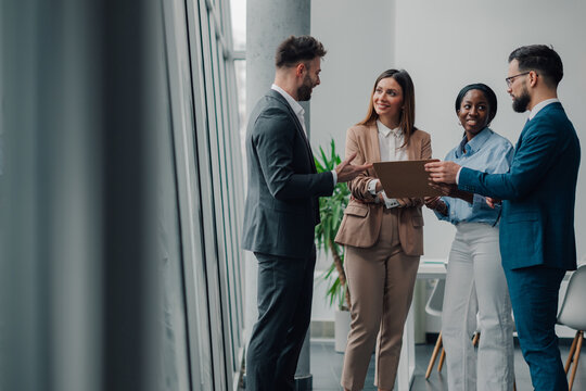 Business people discussing work in modern office with documents
