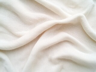 A close-up of soft, white fabric draped in gentle waves, showcasing its texture and translucence.
