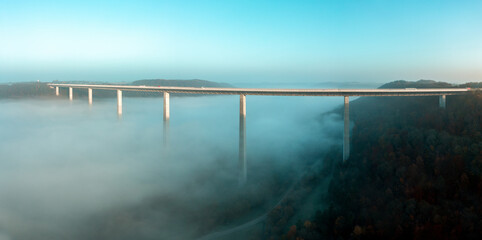 .Highway bridge over dense fog, drone aerial panorama, in Braunsbach, Germany