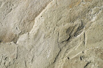 Beige-braune Steinfassade von Fels mit Muster bei Sonne am Morgen im Sommer als Hintergrund