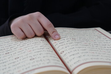 Naklejka premium woman reading quran, quran close up and hand