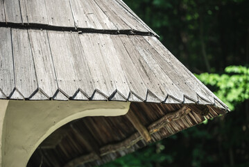 Part of the grey wood roof tiles on an old clay house. Weathered wooden shingles roof on traditional Ukrainian cabin