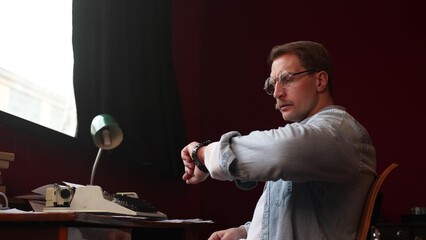 Soft-lit cinematic shot of young writer with typewriter, conceptual image of article writing process.
