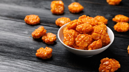 Spicy chilli rice crackers in white bowl. Party food snacks