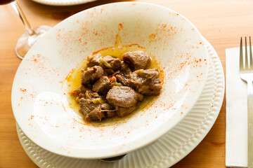 Typical rustic style recipe from La Mancha of fried lamb with young garlic seasoned with paprika