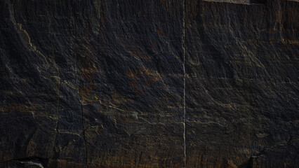 A textured stone background showcasing a brutal, monolithic rock formation with cracks and...