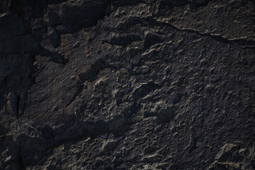 A natural stone texture background with chiaroscuro lighting, featuring a monolithic rock...