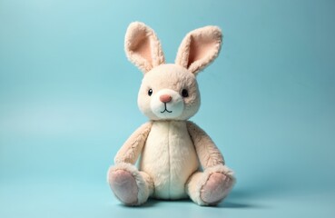 Obraz premium Soft toy rabbit sitting on light blue background. Easter Bunny plush doll, fluffy fur, textile. Symbol of Easter celebration, spring holiday, childhood. Gift for kids, cute design for greeting cards,