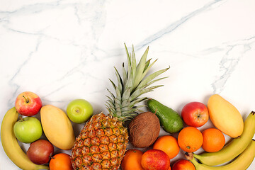 Summer tropical fruits on marble table, source of vitamin C, banner for shop, healthy vegan products for healthy lifestyle, detox diet and weight loss concept, shop advertisement.