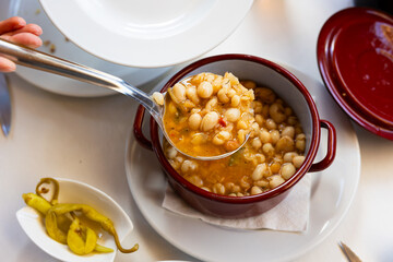 Pochas stewed with vegetables and ham bone in ladle. Aragonese cuisine