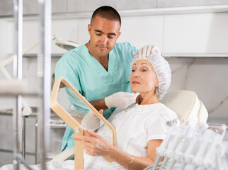 Having concluded treatment, male physician reveals results to satisfied female patient.