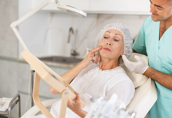 Having concluded treatment, male physician reveals results to satisfied female patient.