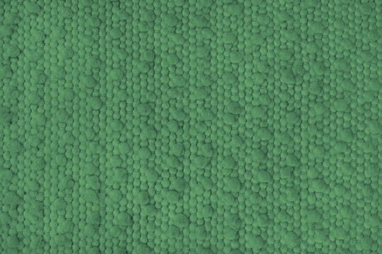 Texture of green carpet fabric with large coarse textured weaving. Surface, structure of upholstery or rug material, cloth background close up, macro.