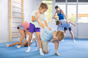 Obraz premium Boy and girl in gym perform basic elements of krav maga self-defense system. Preparation of athletes before competitions